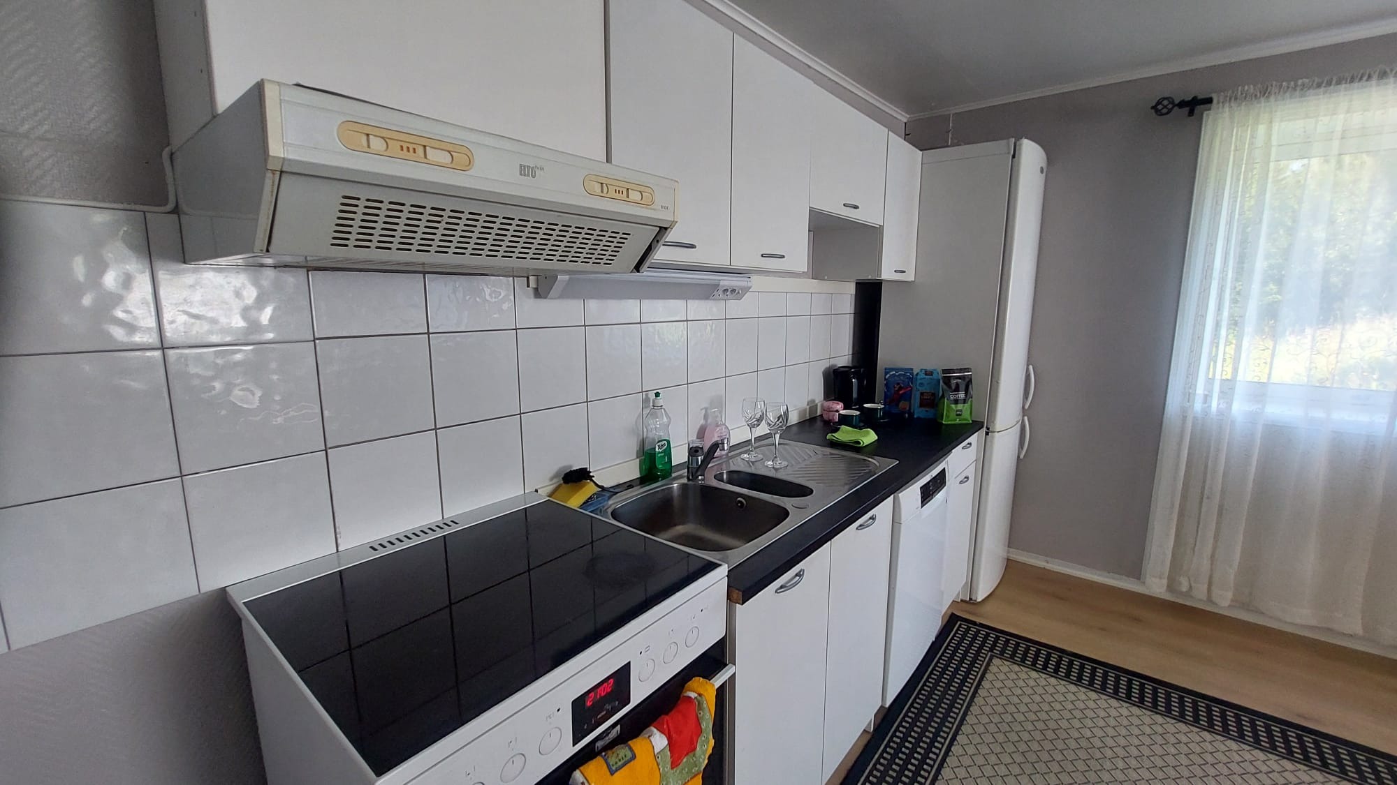 Kjøkken med induksjonsovn, oppvaskmaskin og kjøleskap